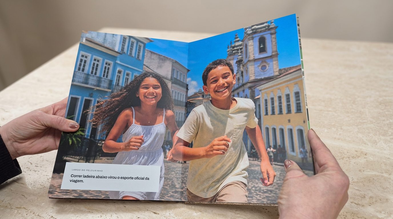 Mãos segurando o livro aberto numa foto de crianças correndo por uma rua colorida